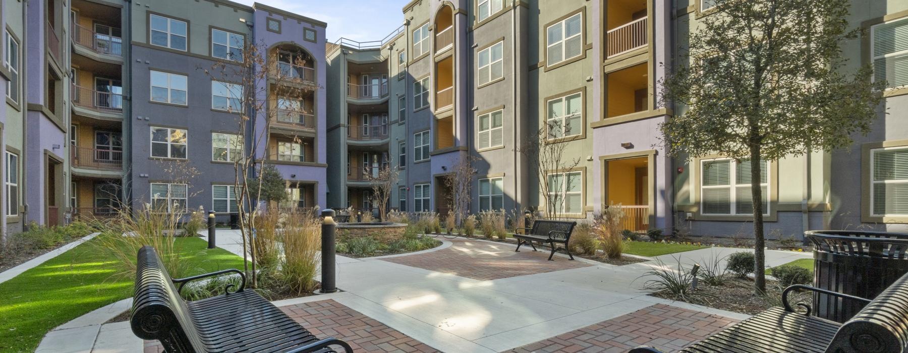 Settle into comfort at Dominion at Mercer Crossing benches in a courtyard in front of a building complex