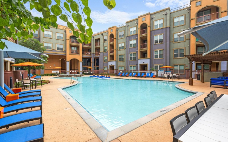 a swimming pool in a courtyard with lounge chairs