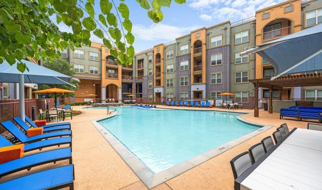 a swimming pool in a courtyard with lounge chairs