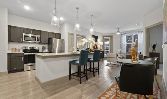a kitchen with a island and chairs and a dining table